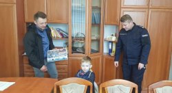 Na zdjęciu widać biuro Komendanta Powiatowego Policji w Ostrzeszowie oraz jak Komendant w swoim biurze gości 5-letniego Maksa oraz jego tatę