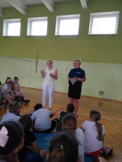 Na zdjęciu widać nauczycielkę ze Szkoły Podstawowej nr 1 w Ostrzeszowie, profilaktyka społecznego z Komendy Powiatowej Policji w Ostrzeszowie, uczniów siedzących twarzą do w/wymienionych osób