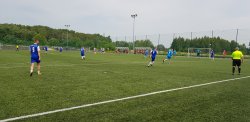Na zdjęciu widać piłkarzy, którzy na boisku grają w piłkę nożną