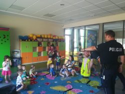 Na zdjęciu widać salę, w której przebywają dzieci oraz słuchają pogadanki umundurowanego policjanta