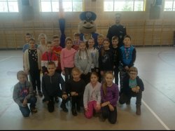 obraz przedstawia grupę dzieci oraz maskotkę wielkopolskiej Policji sierżanta Pyrka