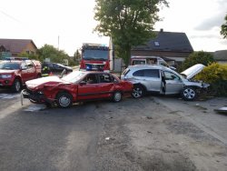 Na zdjęciu widać, dwa pojazdy biorące udział w kolizji w miejscowości Ignaców. W tle ustawiony jest wóz strażacki. Pojazdy posiadają liczne uszkodzenia.